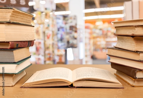 Stack open old books on wooden desk