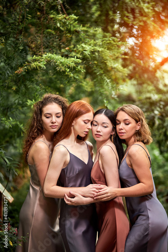 dreamy ladies in elegant dress in the rainforest surrounded by plants, standing with eyes closed posing