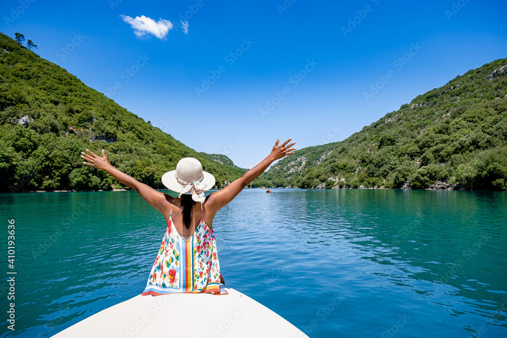 Fototapeta premium cliffy rocks of Verdon Gorge at lake of Sainte Croix, Provence, France, Provence Alpes Cote d Azur, blue green lake with boats in France Provence. Europe, young woman in peddle boat looking at river
