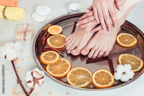 pedicure and manicure in the spa salon with sliced oranges, cinnamon and cotton