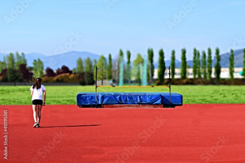 girl athlete in training on the high jump track photo