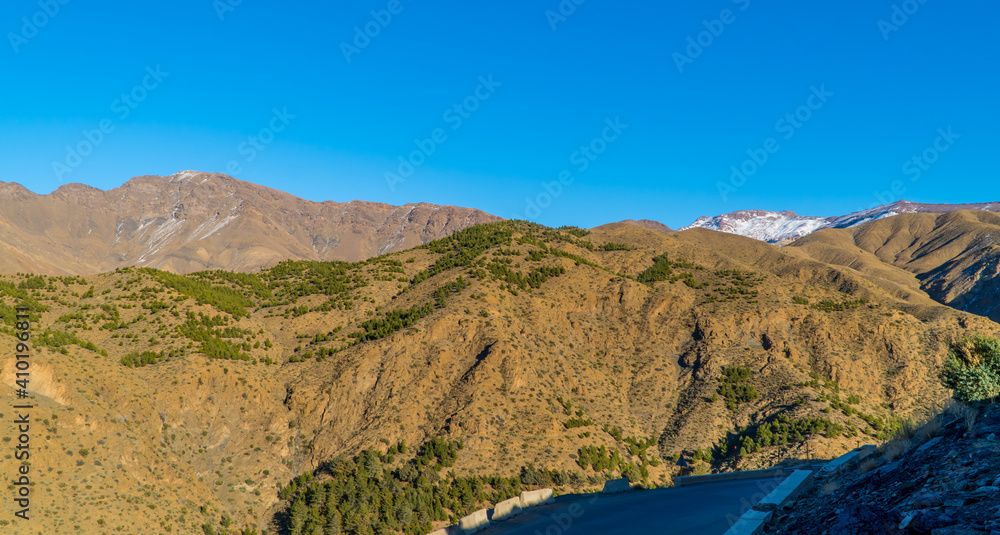 Amazing panorama view of dry mountainous landscapes in the High Atlas mountain range in Morocco with snow-capped peaks