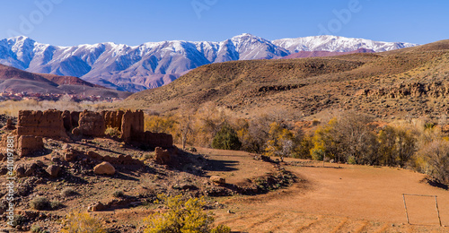 Panoramic view of ruins and landscapes in the High Atlas Mountain Range in Morocco with snow-capped peaks in the background