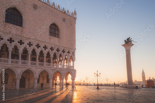 Early morning sun rays beam through arches of the Doge's Palace in St. Mark's Square in Venice, Italy.
