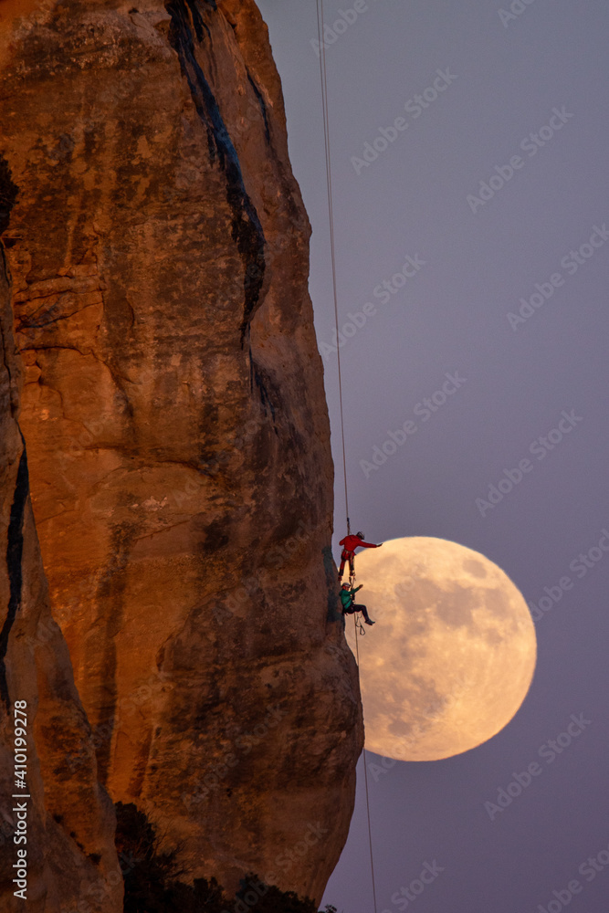 Escalando la luna llena al atardecer