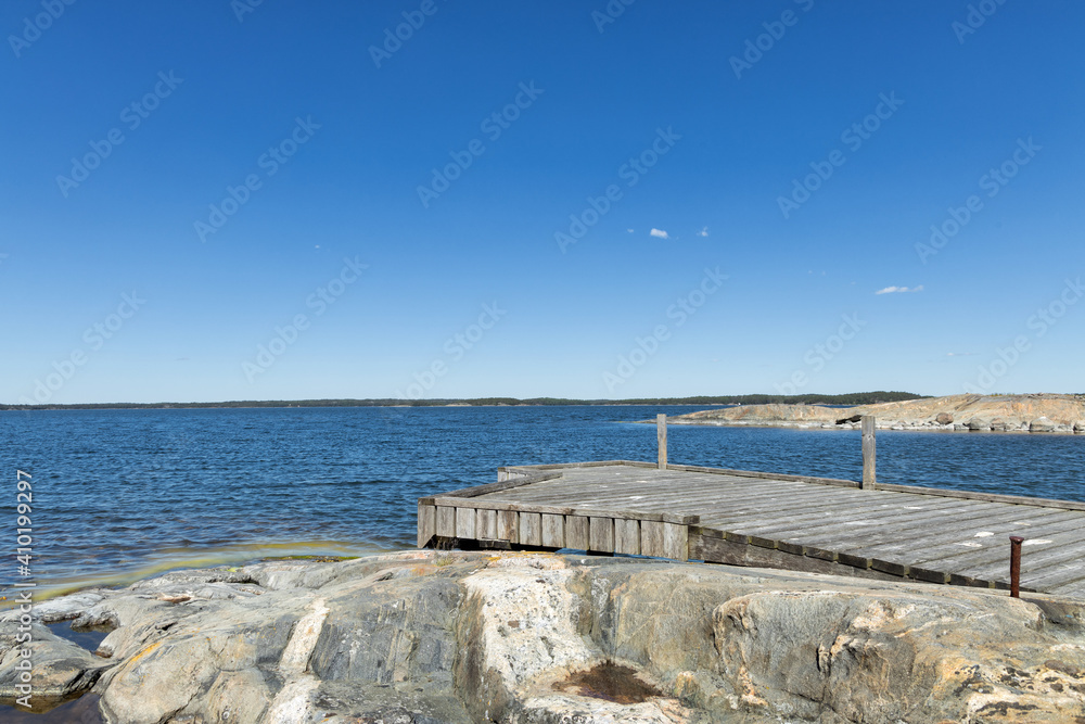 Wooden pier on the sea. Sunny summer day. Blue clear sky. 