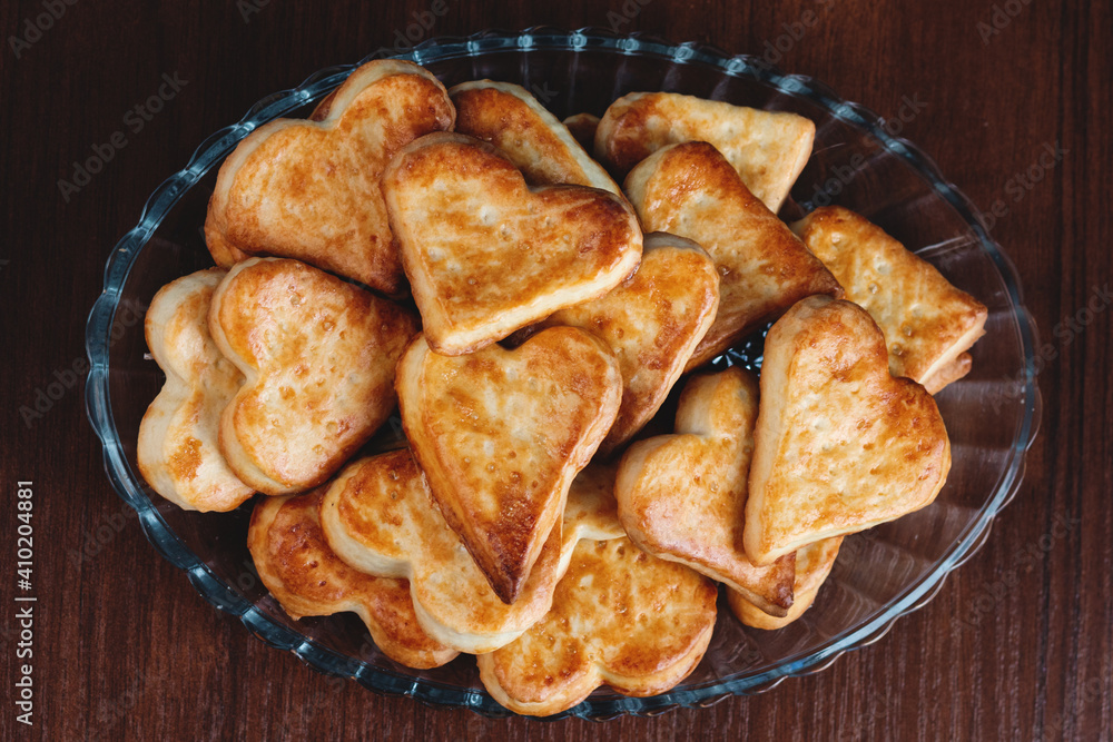 homemade heart shape cookies on a glass plate on a wooden background with film grain effect homemade heart shape cookies on a glass plate on a wooden background with film grain effect