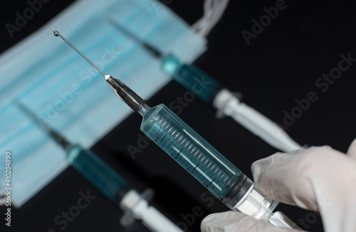 Corona virus Covid-19 vaccine in injection syringe on black. Coronavirus vaccination concept during a global pandemic. Health care and protection. Medical treatment. Liquid drug or narcotic.