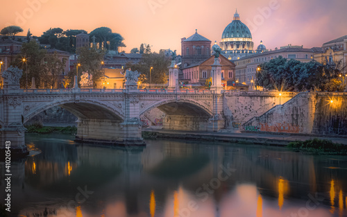 A colourful sunset view of Ponte Vittorio Emanuele II, St. Peter's Basilica and Vatican City over the Tiber River in Rome, Italy.