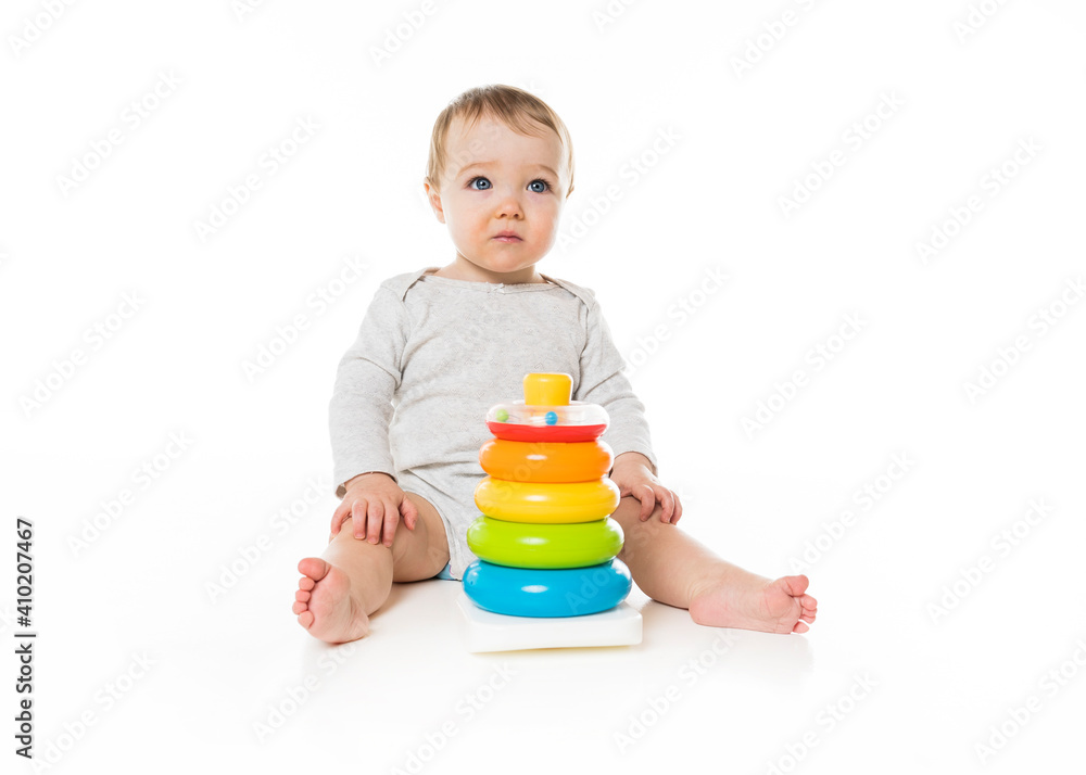 baby girl sitting on floor playing with toy isolated on white background. baby girl sitting on floor playing with toy isolated on white background.