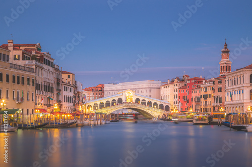 A long exposure of the Grand Canal and Rialto Bridge in Venice, Italy during evening blue hour.
