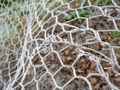 Chain link fence completely frozen by rime caused by fog and low temperatures during winter 
