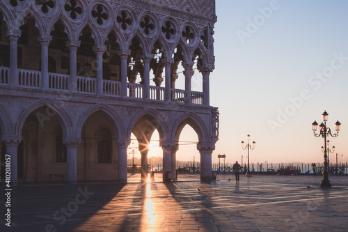 Early morning sun rays beam through arches of the Doge's Palace in Venice, Italy.