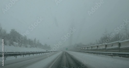 Dashcam POV point of view driving on snowy highway road in Slovenia. Extreme weather conditions on motorway route in winter. Forward moving, wide angle, real time