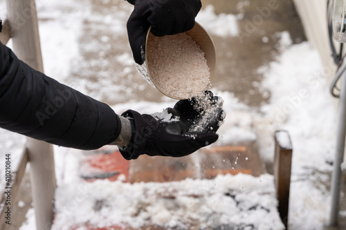 ice melt rock salt is being spread on your walking path to melt the snow and ice