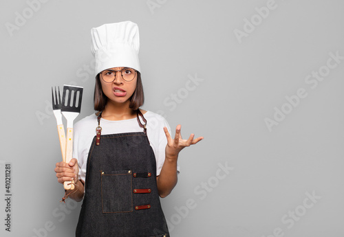 young hispanic woman looking angry, annoyed and frustrated screaming wtf or what’s wrong with you photo