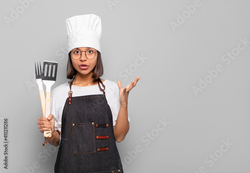 young hispanic woman open-mouthed and amazed, shocked and astonished with an unbelievable surprise photo