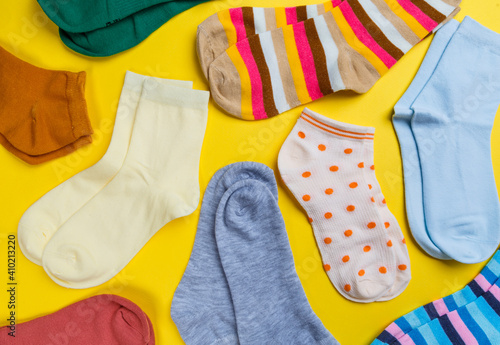 View from above. Socks are scattered on a yellow background. Clothing in the form of socks.