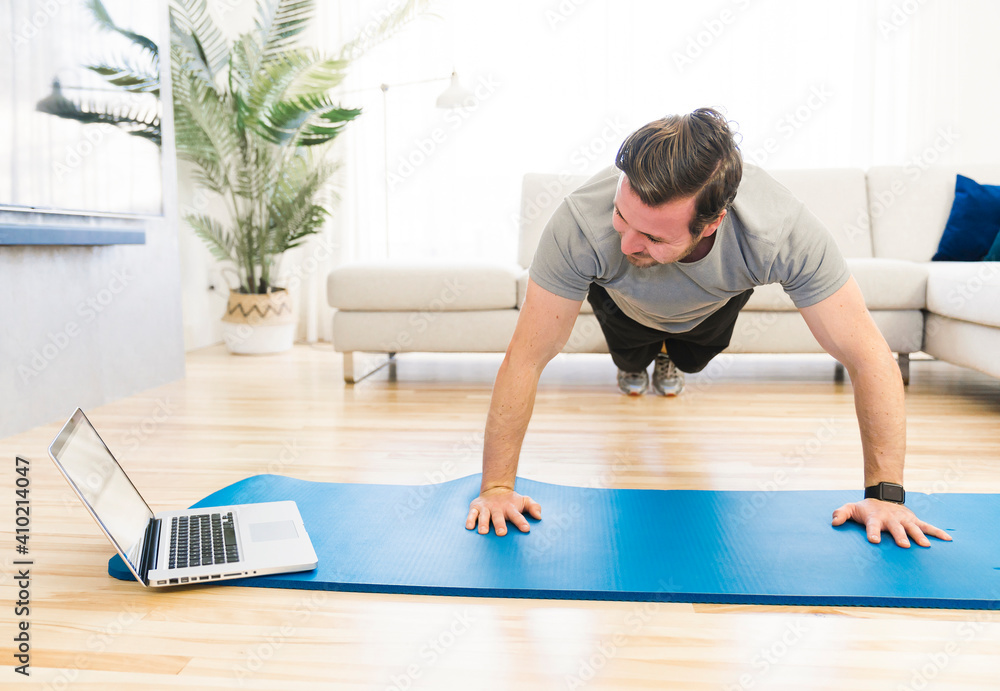 Attractive Fit man Exercise at home on the living room