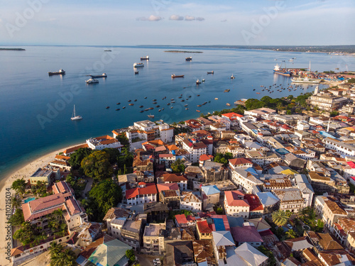 Zanzibar Aerial Shot of Stone Town Beach with Traditional Dhow Fisherman Boats in the Ocean at Sunset Time photo