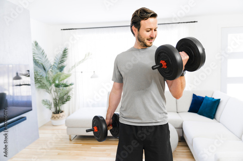 Attractive Fit man Exercise at home on the living room with dumbell on hand