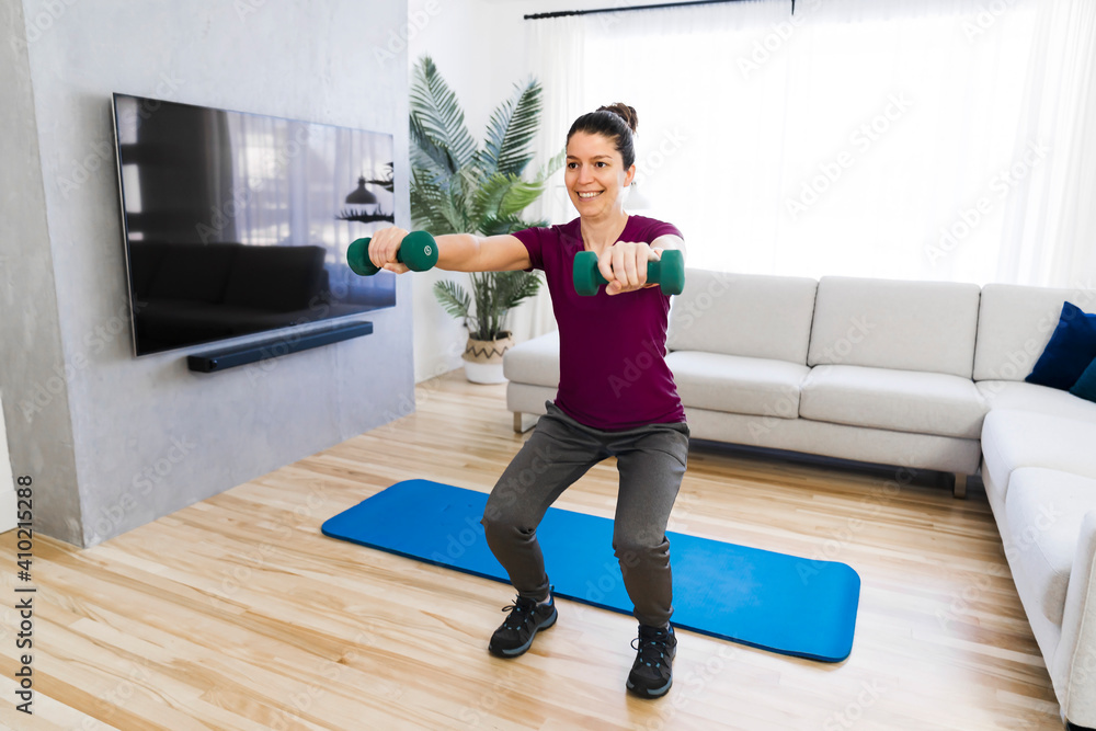 Attractive Fit woman Exercise at home on the living room with dumbell on hand Attractive Fit woman Exercise at home on the living room with dumbell on hand