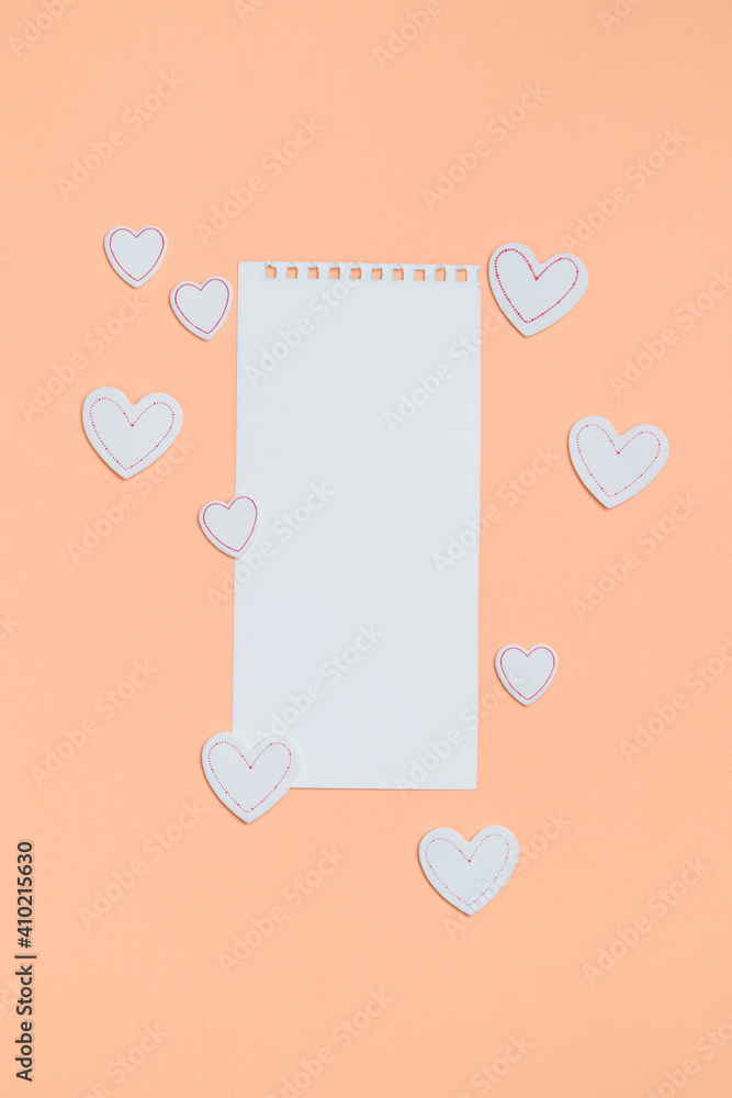Elements in shape of white hearts on orange background surrounding white paper. Symbols of love for Happy Women's, Mother's, Valentine's Day, birthday greeting card design. Elements in shape of white hearts on orange background surrounding white paper. Symbols of love for Happy Women's, Mother's, Valentine's Day, birthday greeting card design.