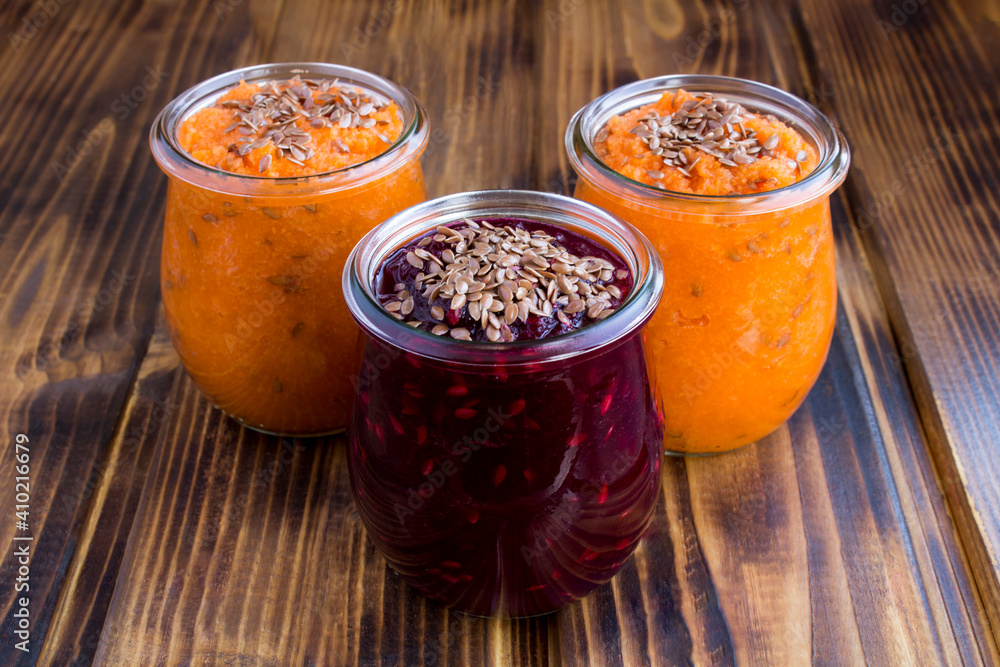 Closeup on vegetable smoothies or puree with flax seeds in the glass jars on the wooden table Closeup on vegetable smoothies or puree with flax seeds in the glass jars on the wooden table