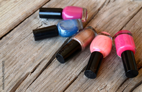 Colorful, bright and glittery nail polish bottles on a wooden background.Manicure tools, beauty, nail art concept. 