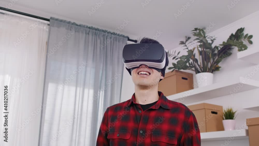 Cheerful Asian man smiling, using virtual reality 3d glasses. High quality 4k footage Cheerful Asian man smiling, using virtual reality 3d glasses. High quality 4k footage