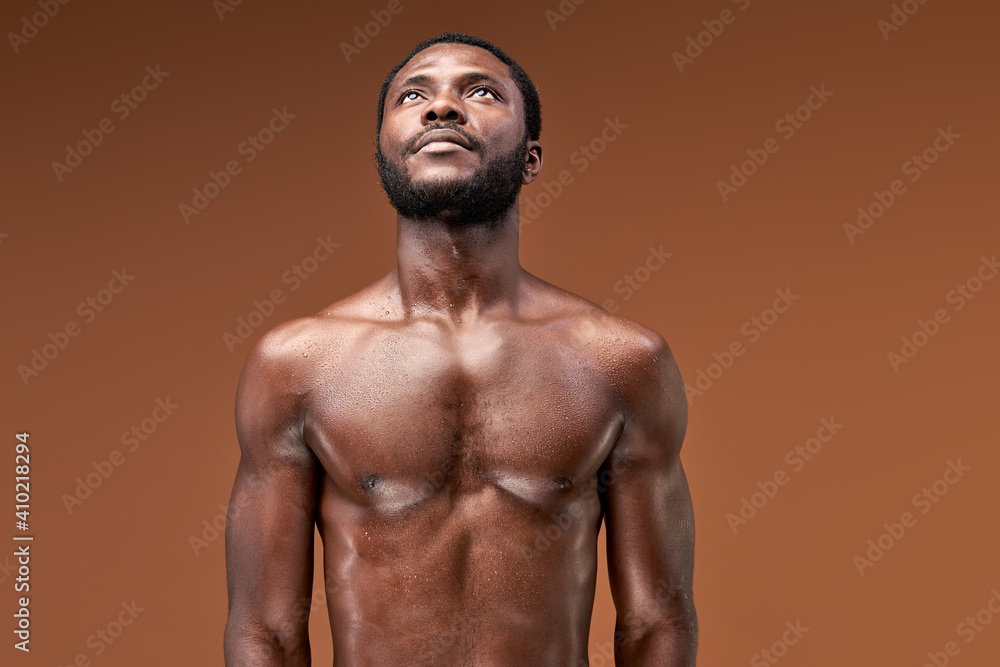 black sportsman posing at camera after active intense training, he is looking up, sweaty and exhausted