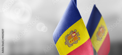 Small national flags of the Andorra on a light blurry background