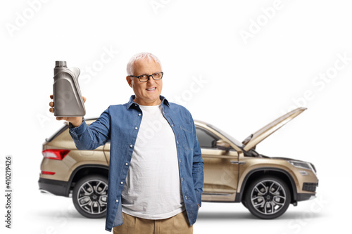 Mature man in front of a suv holding a motor oil