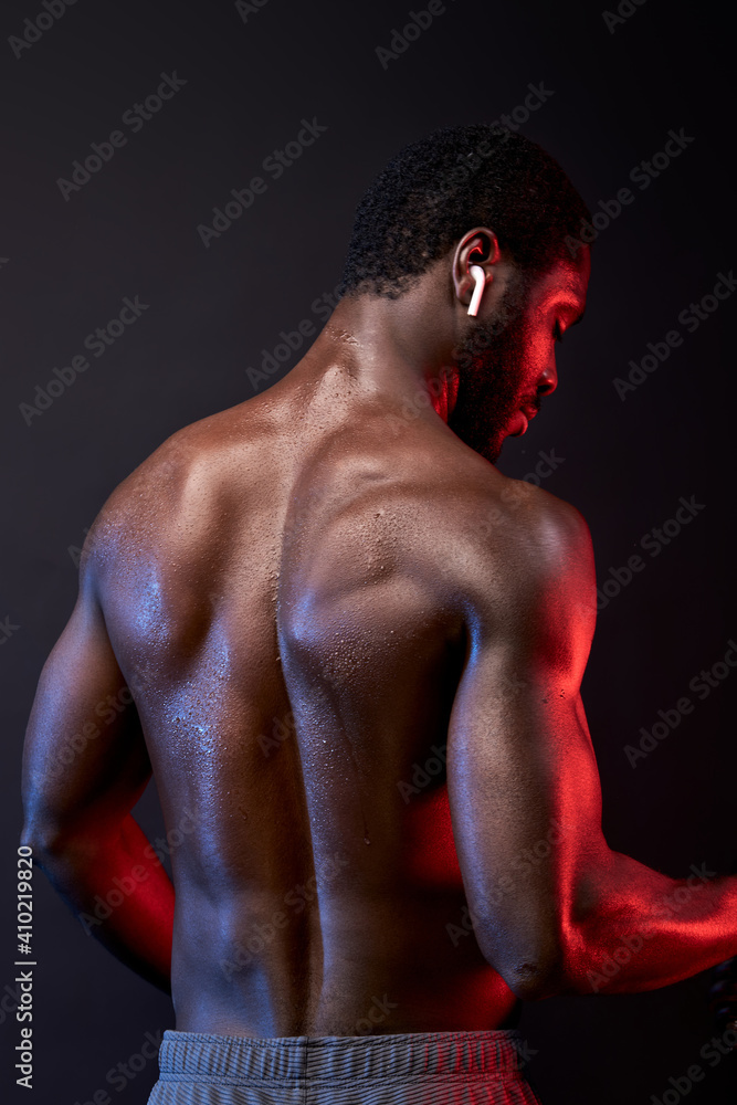 african man with muscular body against black background, shirtless male