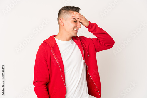 Young caucasian handsome man isolated laughs joyfully keeping hands on head. Happiness concept.