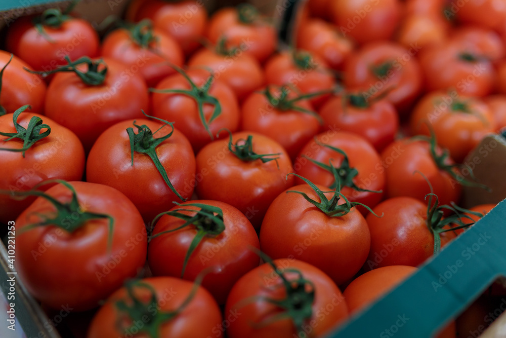 Soft focused shot of vegetable department in grocery store, supermarket, mall, hypermarket or shopping center. Boxes with tomatoes. Vegan healthy food concept. Soft focused shot of vegetable department in grocery store, supermarket, mall, hypermarket or shopping center. Boxes with tomatoes. Vegan healthy food concept.