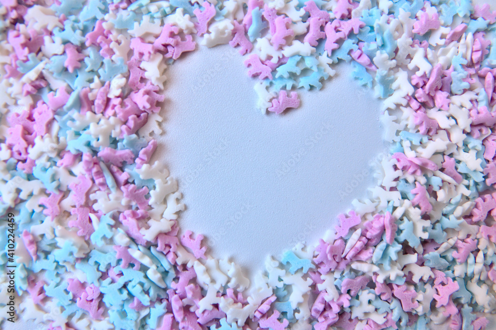 Delicious sugar candy unicorns in red, blue and white as sweet cake decoration and birthday topping with little horses and unicorn sprinkles show love for confection frosting of hearts
