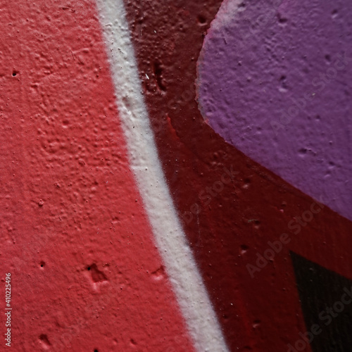 Detail of a sprayed wall. Colors: red, wine-red, white, black and purple. Color on concrete. Background
