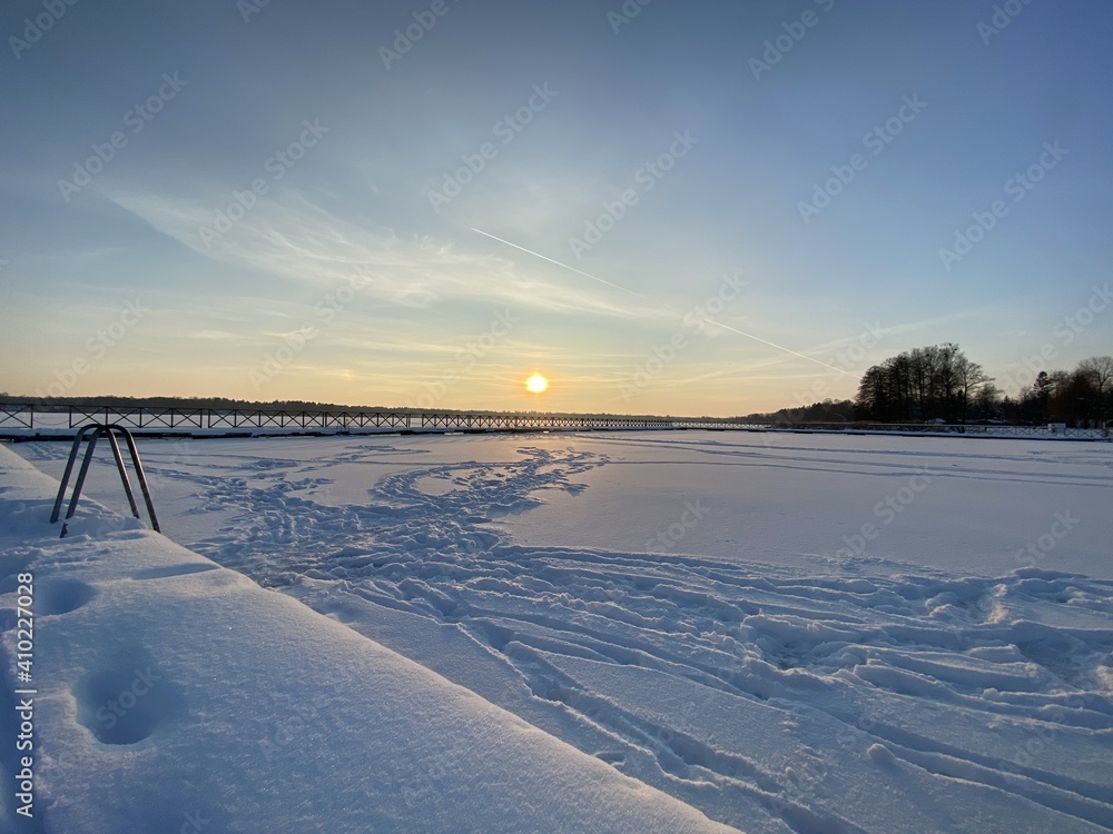 View of the frozen Białe Lake near Włodawa with wooden decks a lot of snow just before sunset golden hour