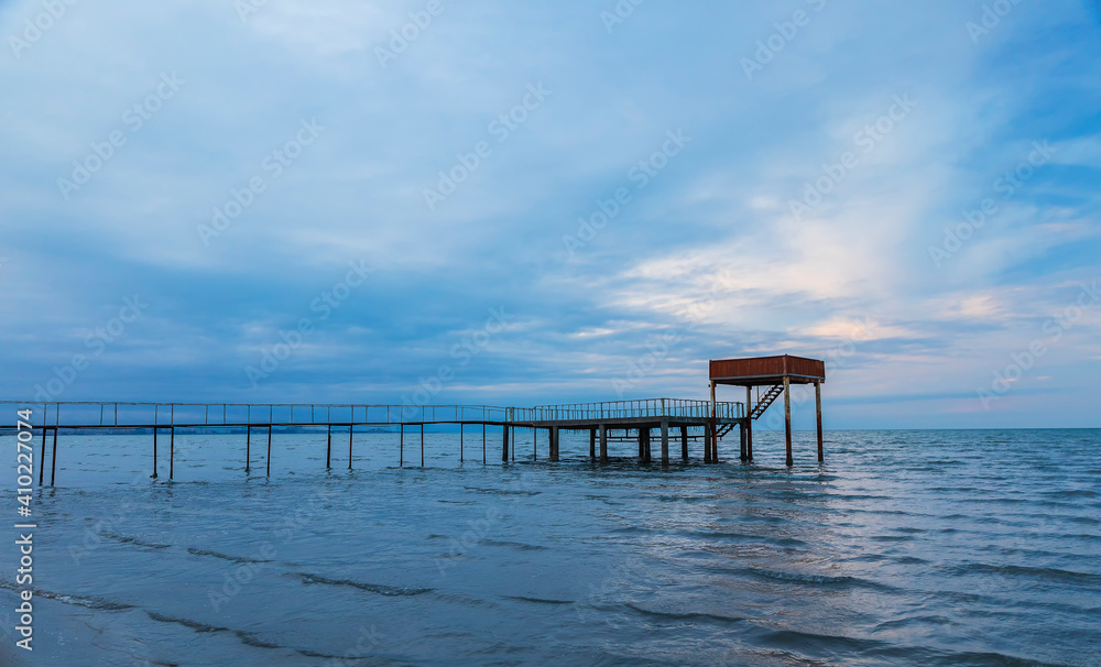 A pier going out to sea at sunset