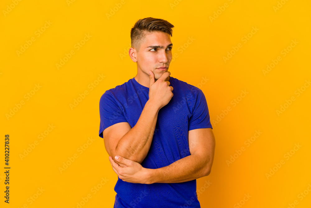 Young handsome caucasian man isolated looking sideways with doubtful and skeptical expression. Young handsome caucasian man isolated looking sideways with doubtful and skeptical expression.