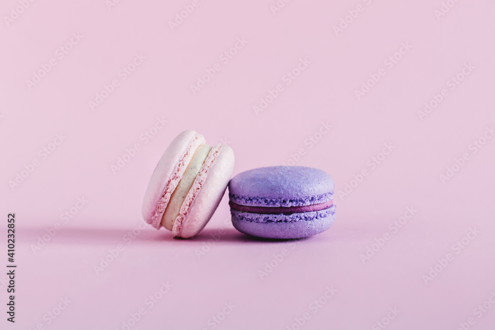 Tasty french macarons on a pink pastel background. Pink and violet macarons. Place for text. Tasty french macarons on a pink pastel background. Pink and violet macarons. Place for text.