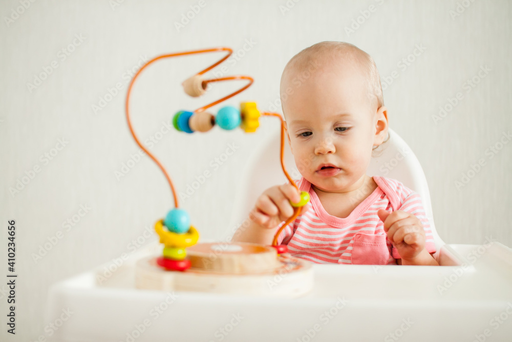 little girl plays with an educational maze toy. Development of fine motor skills and logical thinking. High quality photo little girl plays with an educational maze toy. Development of fine motor skills and logical thinking. High quality photo