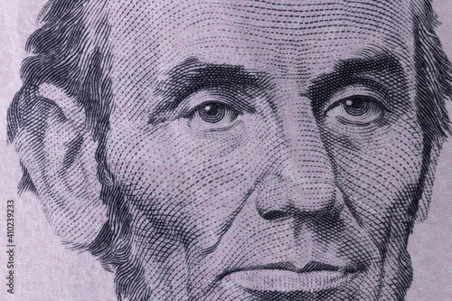 President Abraham Lincoln on the obverse of a five dollar bill for background.