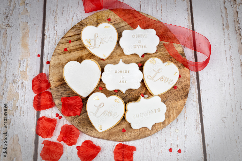 Wedding-themed cookies displayed on a wooden board