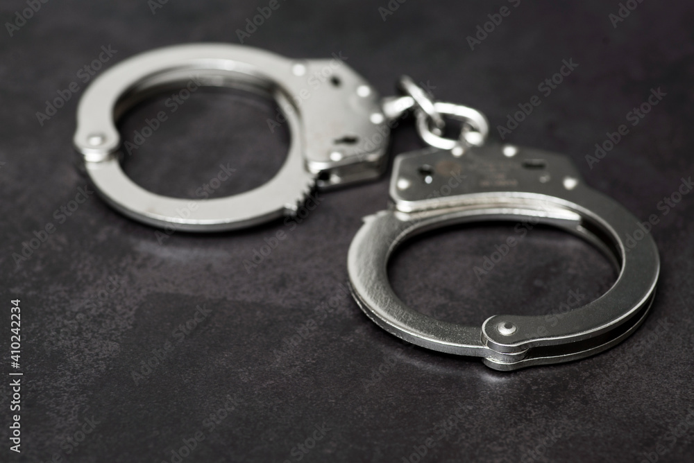 The metal handcuffs on black background. Handcuff or shackle. Police handcuffs The metal handcuffs on black background. Handcuff or shackle. Police handcuffs