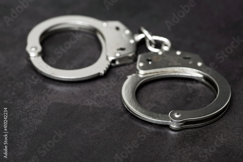 The metal handcuffs on black background. Handcuff or shackle. Police handcuffs