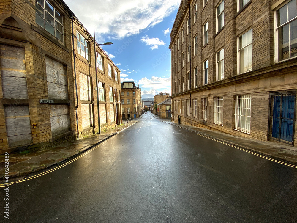 Looking into the distance down, Chapel Street, lined with Victorian stone buildings in, Little Germany, Bradford, UK