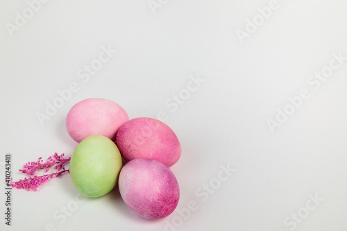 Multi-colored eggs with twigs  on a white background with a place for text.
