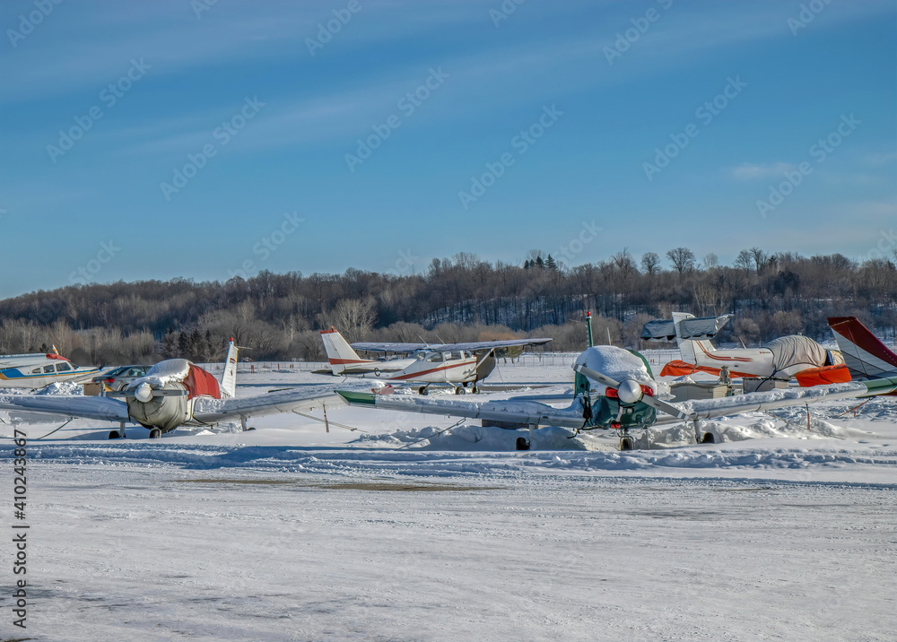 Obraz premium Private aircraft parked on runway tarmac at private airport in winter with snow on ground nobody